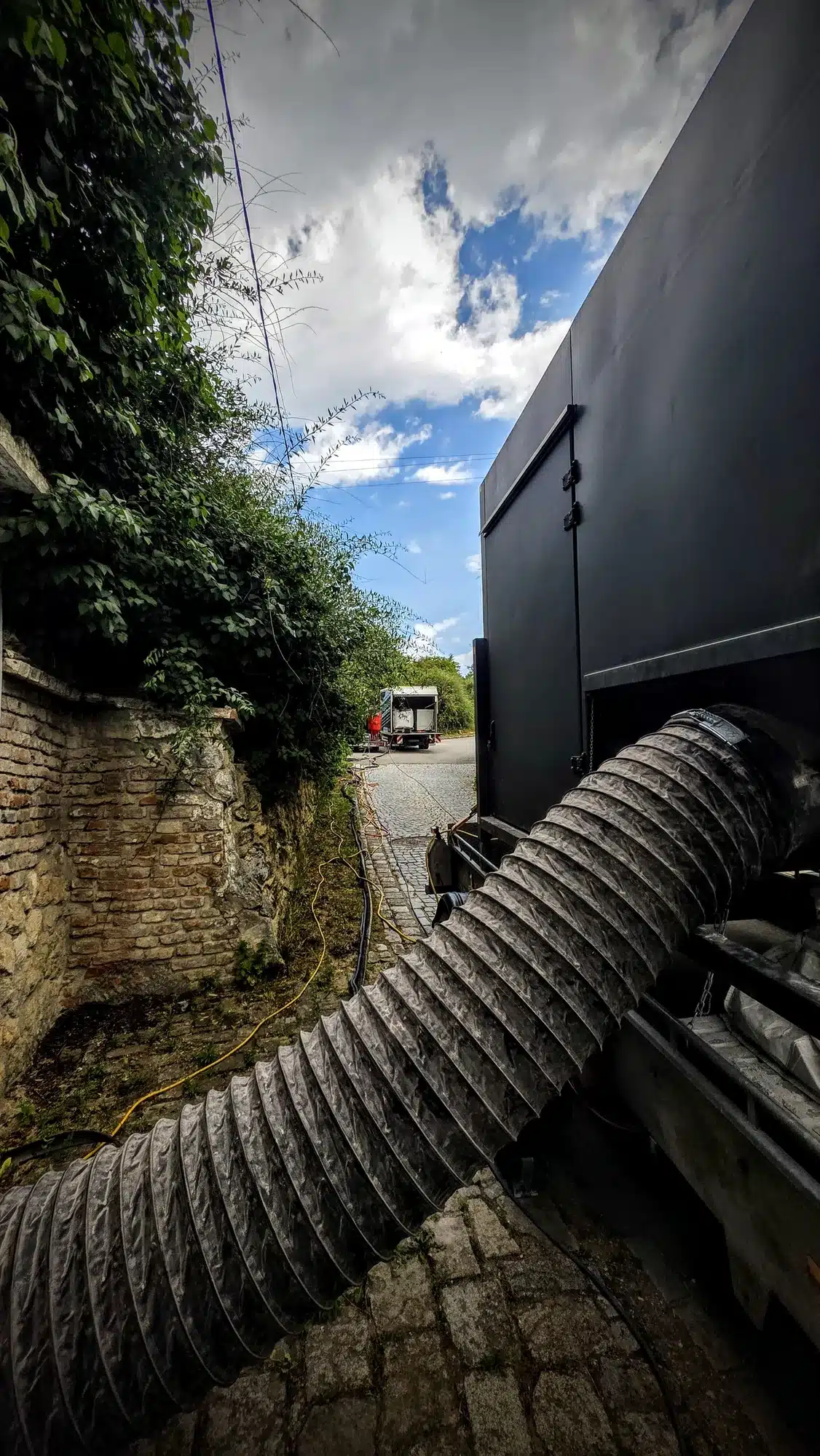 Mobile Entstaubungsanlage mit H13-Filter und Saugschlauch vor dem Kellereingang