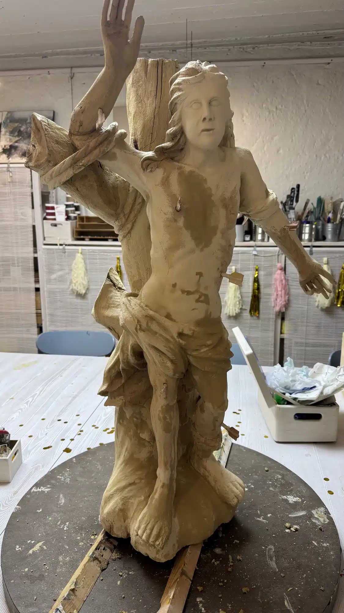 Holzfigur des hl. Sebastian nach der Grundierung in cremefarbenem Kreidegrund im Atelier