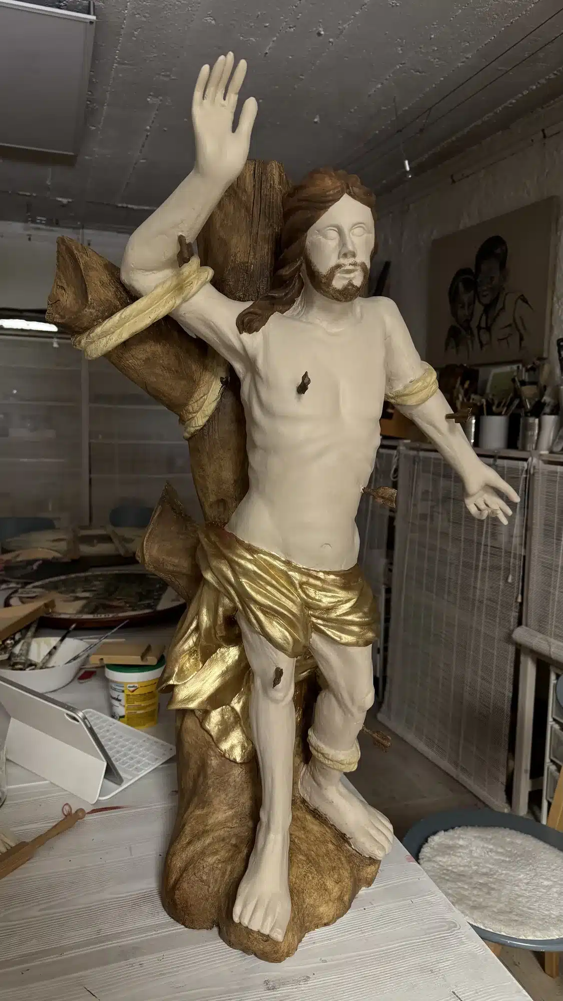 Sebastiansfigur während der Bemalung mit Hautton und frisch vergoldetem Lendentuch